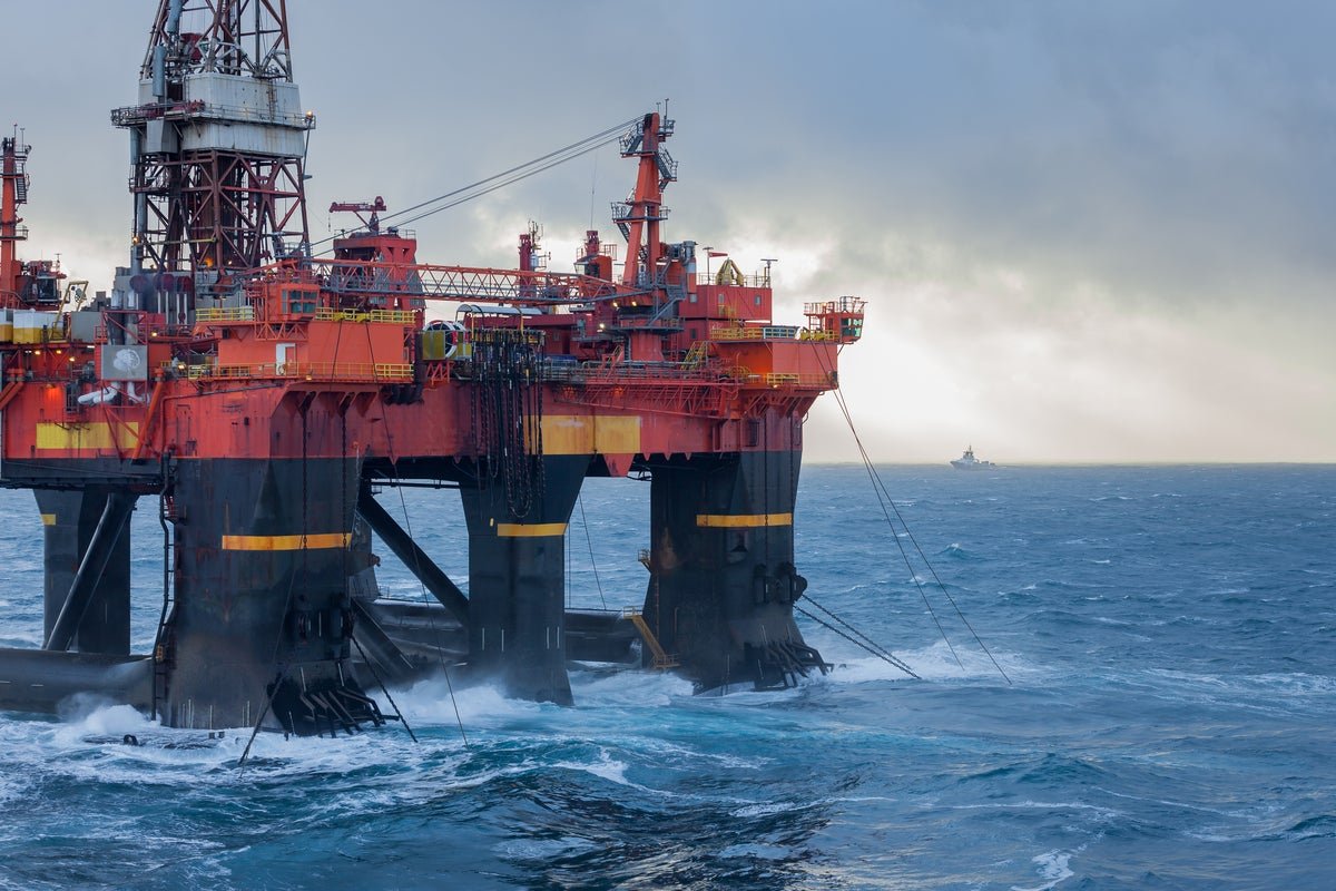 A drilling platform in the North Sea, with a ship nearby, highlighting the importance of North Sea drilling for the UK's energy supplies and security, with a beautiful colour landscape of the sea
