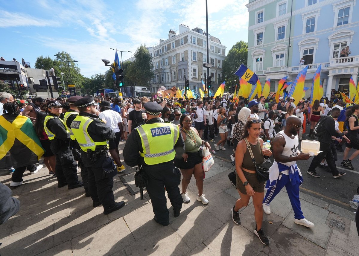 A colourful and vibrant scene from the Notting Hill Carnival, with people dancing and playing music in the streets, showcasing the event's cultural significance and the primary keyword, Notting Hill Carnival