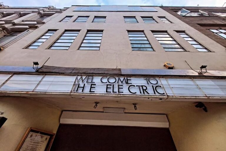 A photo of Birmingham's iconic landmark, with a crowd of people rallying in the foreground, demanding urgent action to save the beloved city centre staple, with a bright colour scheme and a sense of community behaviour