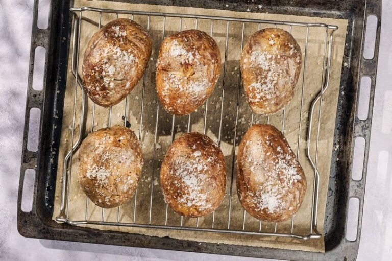 A photo of a delicious jacket potato with various toppings, taken outside the now-closed Cardiff jacket potato café, a popular spot for foodies and locals alike, with a sign reading 'closed' in the background, highlighting the café's difficult decision to close its doors