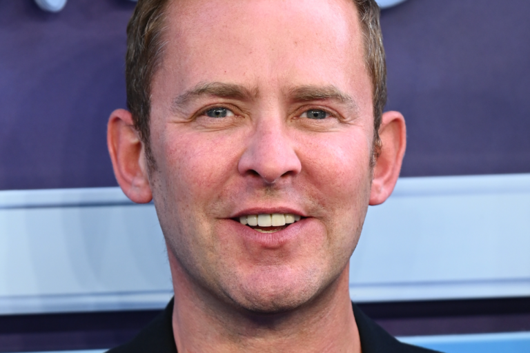 BBC Radio 2 studio with a presenter sitting at a desk, surrounded by screens and audio equipment, with a cityscape in the background, representing the station's commitment to music trends and entertainment, with the primary keyword being radio presenter