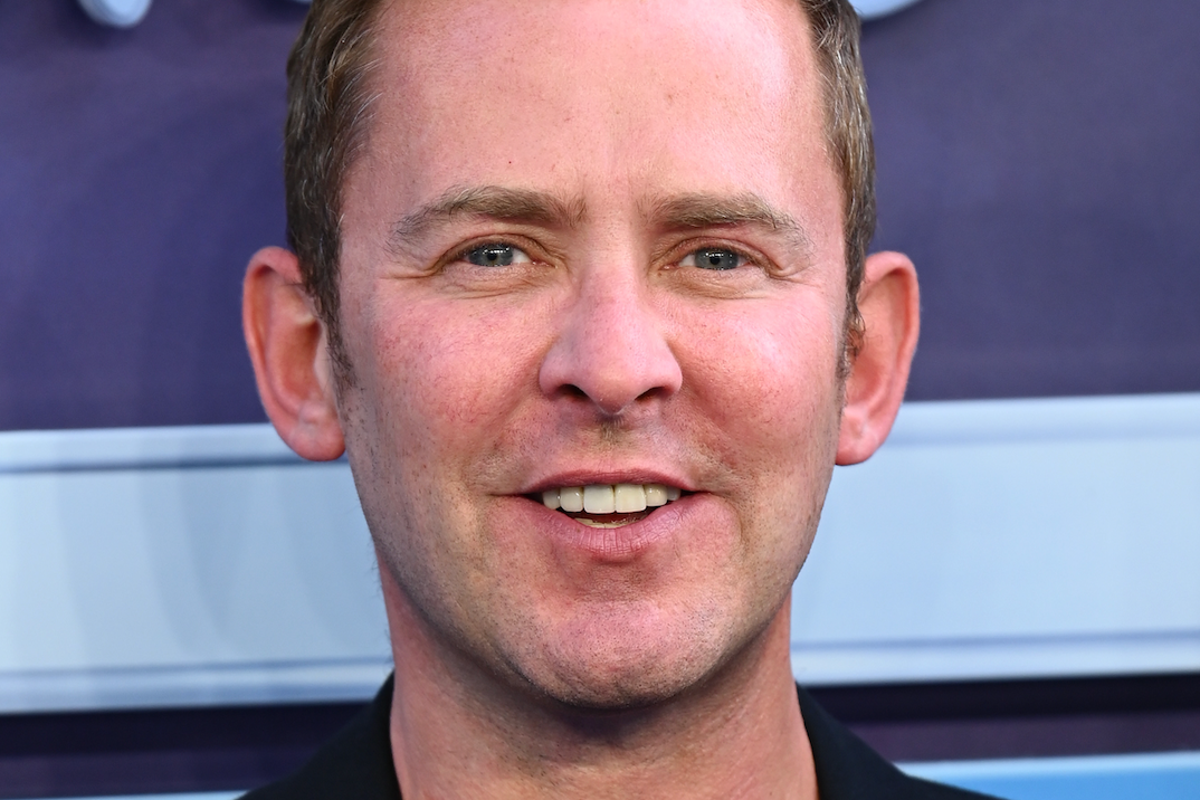 BBC Radio 2 studio with a presenter sitting at a desk, surrounded by screens and audio equipment, with a cityscape in the background, representing the station's commitment to music trends and entertainment, with the primary keyword being radio presenter