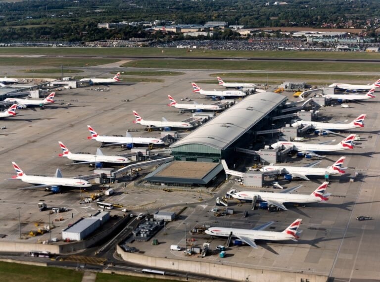 A plane sitting on the runway with a fuel truck in the background, highlighting the importance of fuel for flights and the potential for fuel shortages to cause cancellations