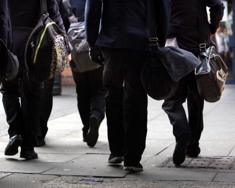 A group of young boys in a school setting, looking concerned and unsure, highlighting the masculinity crisis in UK schools, with a need for a more nuanced understanding of masculinity and its impact on mental health and relationships