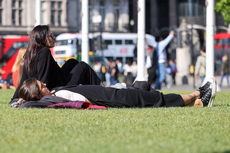 A descriptive image of a sunny day in London, with people enjoying the warm weather in a park, with the primary keyword phrase London weather naturally included