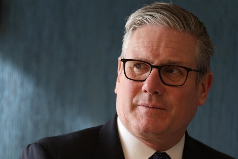 A descriptive image of a person holding a sign that reads 'Stop Benefit Cuts', with a blurred background of people protesting, highlighting the primary keyword 'benefits cuts' and the impact on vulnerable citizens