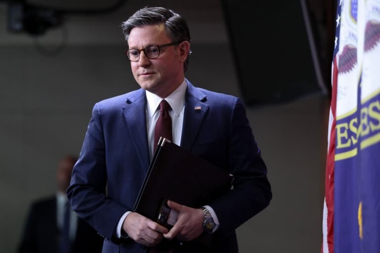 Mike Johnson speaking in parliament, surrounded by furious allies, with a bait-and-switch tactic in the background, highlighting the controversy surrounding his actions on the DHS bill