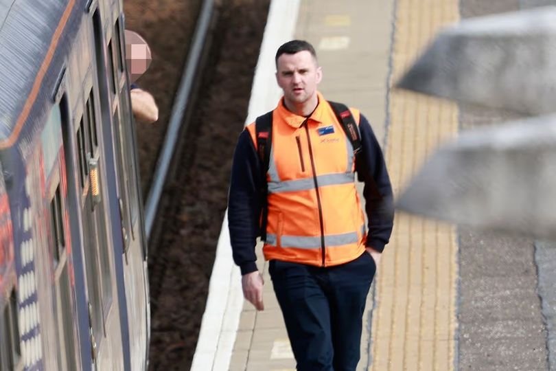 A train driver in the cab of a ScotRail train, with a blurred background to represent the controversy surrounding the recruitment of an ex-cop with a criminal record, highlighting the need for robust vetting procedures to ensure public safety