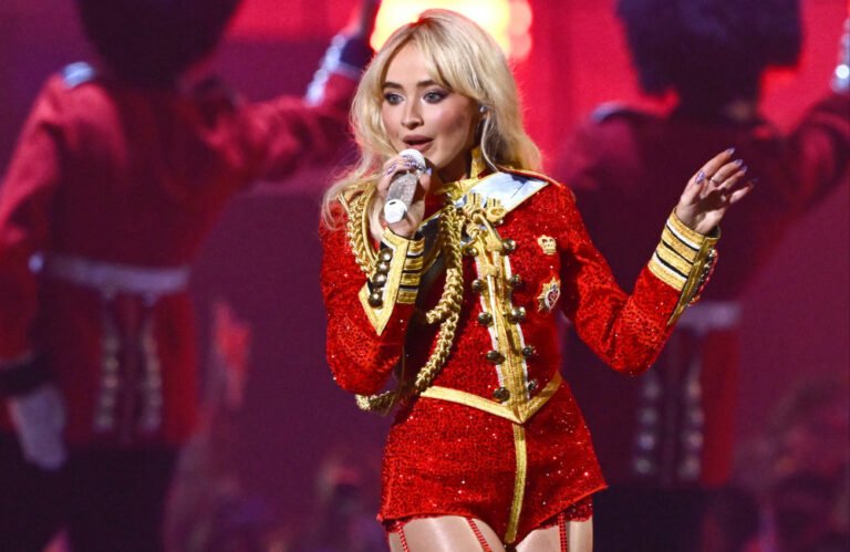 Sabrina Carpenter performing live on stage with a colourful background and energetic crowd, showcasing her captivating stage presence and powerful voice at Coachella music festival