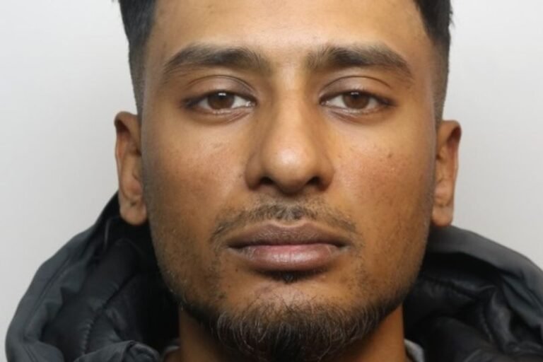 A person holding a sign that says 'support for domestic abuse victims' with a blurred background of a person in handcuffs, representing the seriousness of domestic abuse and the importance of seeking help and support
