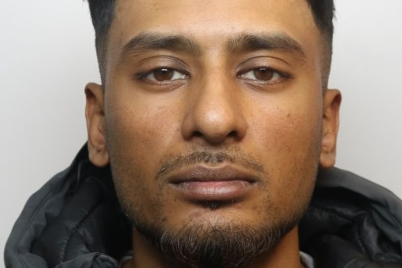 A person holding a sign that says 'support for domestic abuse victims' with a blurred background of a person in handcuffs, representing the seriousness of domestic abuse and the importance of seeking help and support