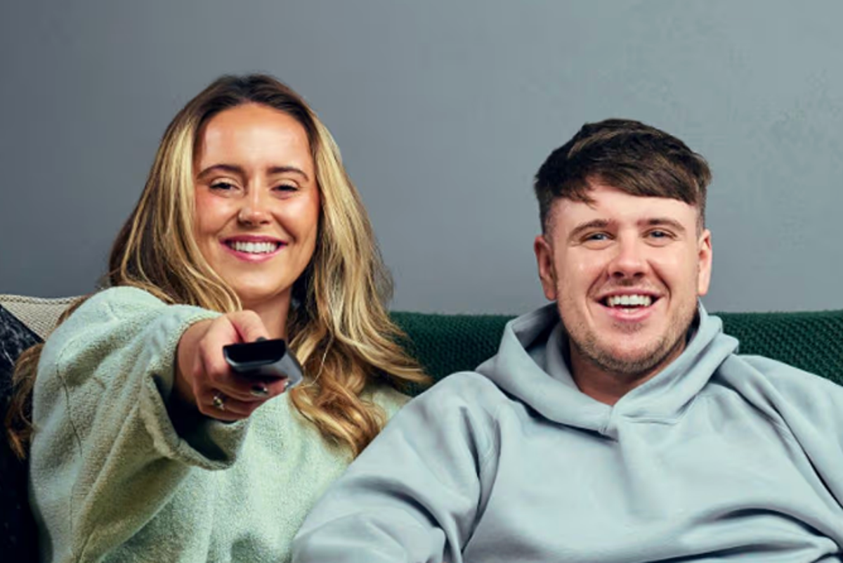 Gogglebox couple sitting on a couch, looking sad and shocked, with a TV in the background, featuring the popular Channel 4 series, with a focus on the couple's behaviour and relationship