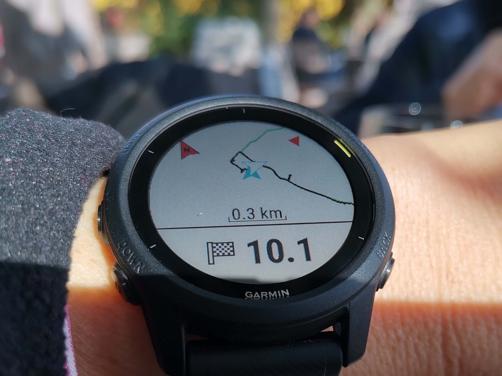 A Garmin smartwatch on a user's wrist, with a glitchy screen displaying an error message, highlighting the ongoing issues with Garmin wearables in the UK, particularly when used with Apple devices