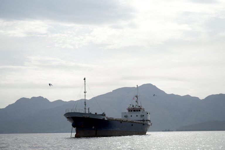 Chinese flag waving in the wind, with a backdrop of oil rigs and ships, symbolising China's economic interests in the Iran conflict, including oil imports and trade ties
