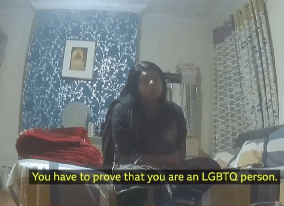 Two people being arrested in east London over a migrant scam involving fake gay visas, with a city landscape in the background, highlighting the primary keyword phrase 'migrant scam' in a descriptive alternative text
