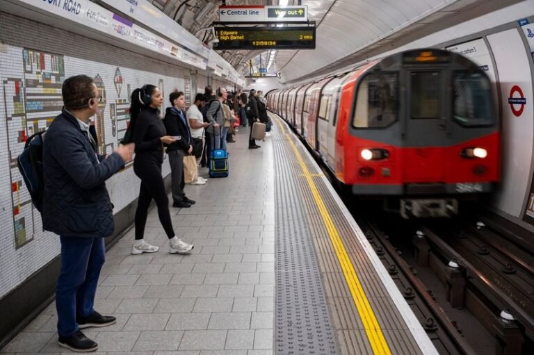 A crowded London Tube platform with a sign indicating a strike, highlighting the disruptions caused by the London Tube strikes in April 2026, with commuters waiting for alternative transport options