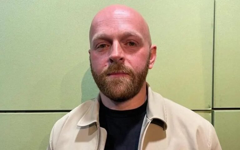 A Morrisons store front with a sign reading 'shoplifting is a crime' and a security guard standing outside, highlighting the company's approach to retail crime and shoplifting