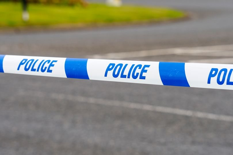A police officer in South London stands near a cordoned-off area where gunshots were heard, with a recovered weapon being examined by forensic experts, highlighting the primary keyword of gun crime