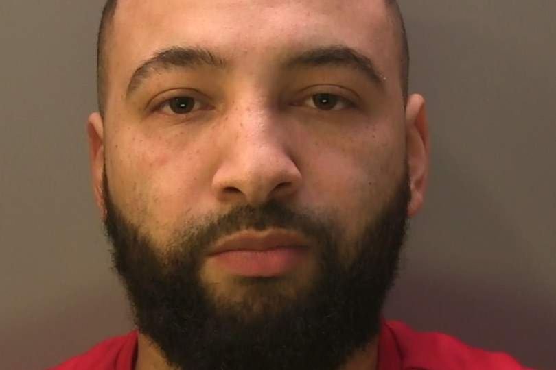 A descriptive image of a prison wall with a mobile phone and drugs being thrown over, highlighting the primary keyword of prison smuggling in a natural and contextual manner, with a focus on the behaviour and colour of the scene