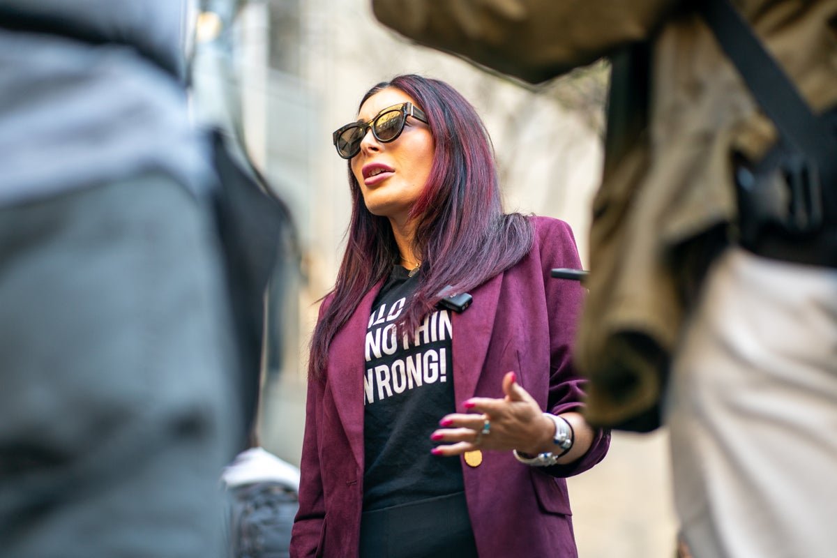 Laura Loomer, a prominent American activist, speaking at a rally, with a crowd of people in the background, highlighting her controversial behaviour and outspoken views, as she loses defamation case against Bill Maher