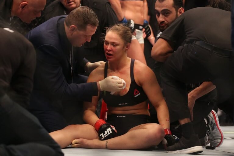 Ronda Rousey in action during her UFC fight against Holly Holm, showcasing her skill and determination in the octagon, a true pioneer of women's mixed martial arts