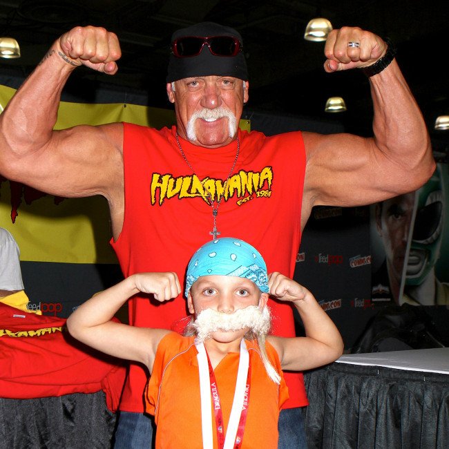 Hulk Hogan standing in the ring, with a confident expression, surrounded by a sea of adoring fans, highlighting his lasting impact on the world of wrestling and beyond