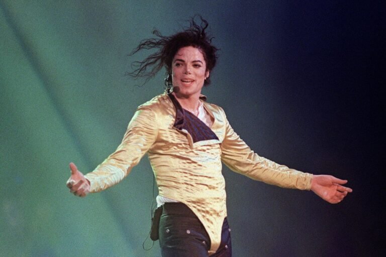 A photo of Michael Jackson performing on stage, with a crowd of fans in the background, highlighting the colour and energy of his live performances, with a focus on the primary keyword, Michael Jackson biopic