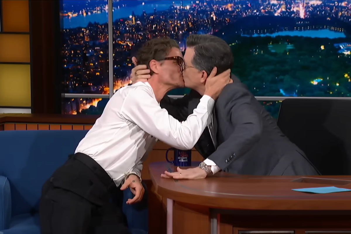 Pedro Pascal and Stephen Colbert sharing a kiss on The Late Show, a moment that showcases their ability to have fun and not take themselves too seriously, with a focus on celebrity news and entertainment
