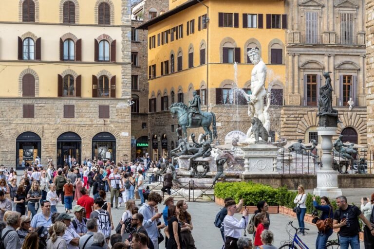A beautiful historic fountain in Florence, Italy, with intricate design and stunning colour, surrounded by tourists and locals alike, with a sense of excitement and joy, but also a need for respect and preservation of cultural heritage
