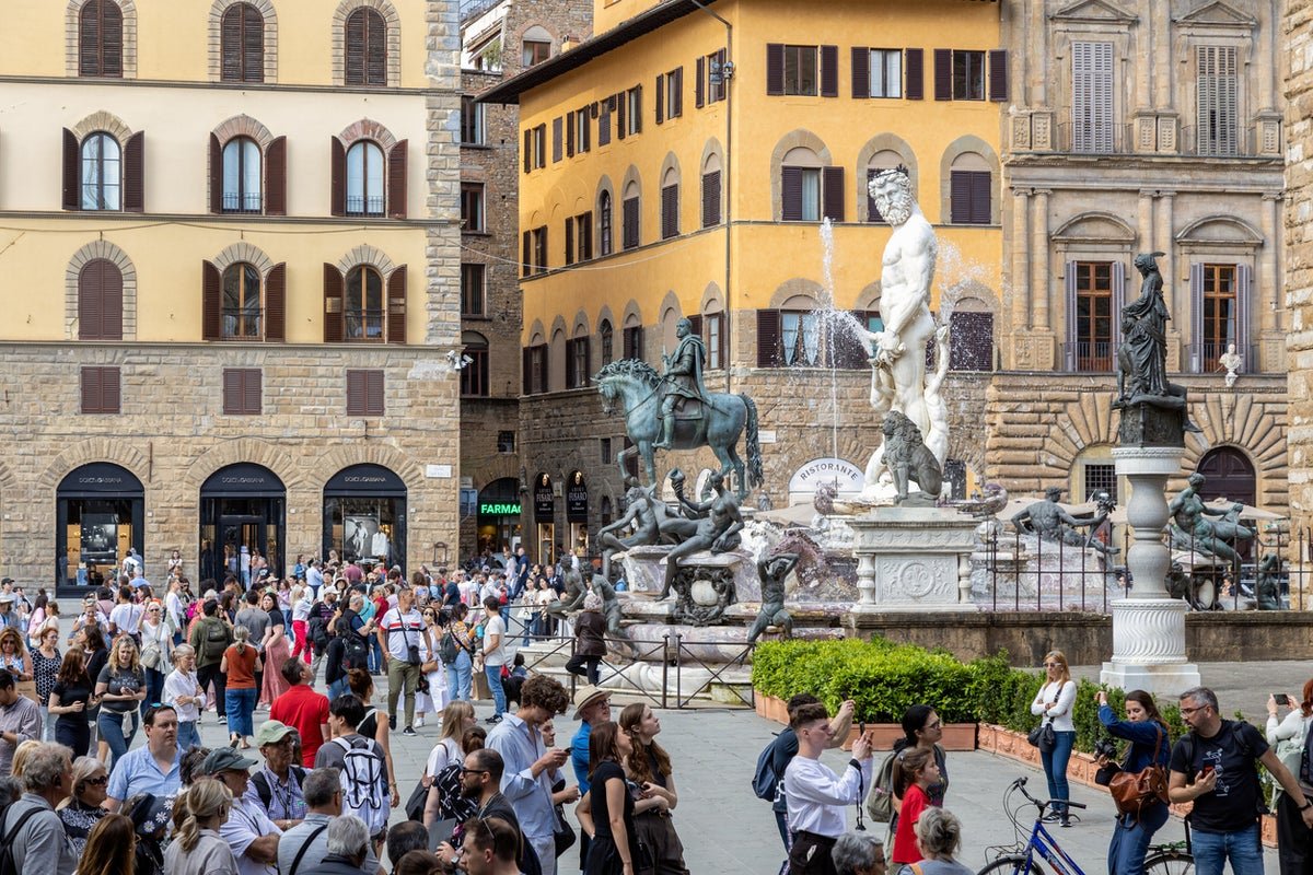 A beautiful historic fountain in Florence, Italy, with intricate design and stunning colour, surrounded by tourists and locals alike, with a sense of excitement and joy, but also a need for respect and preservation of cultural heritage