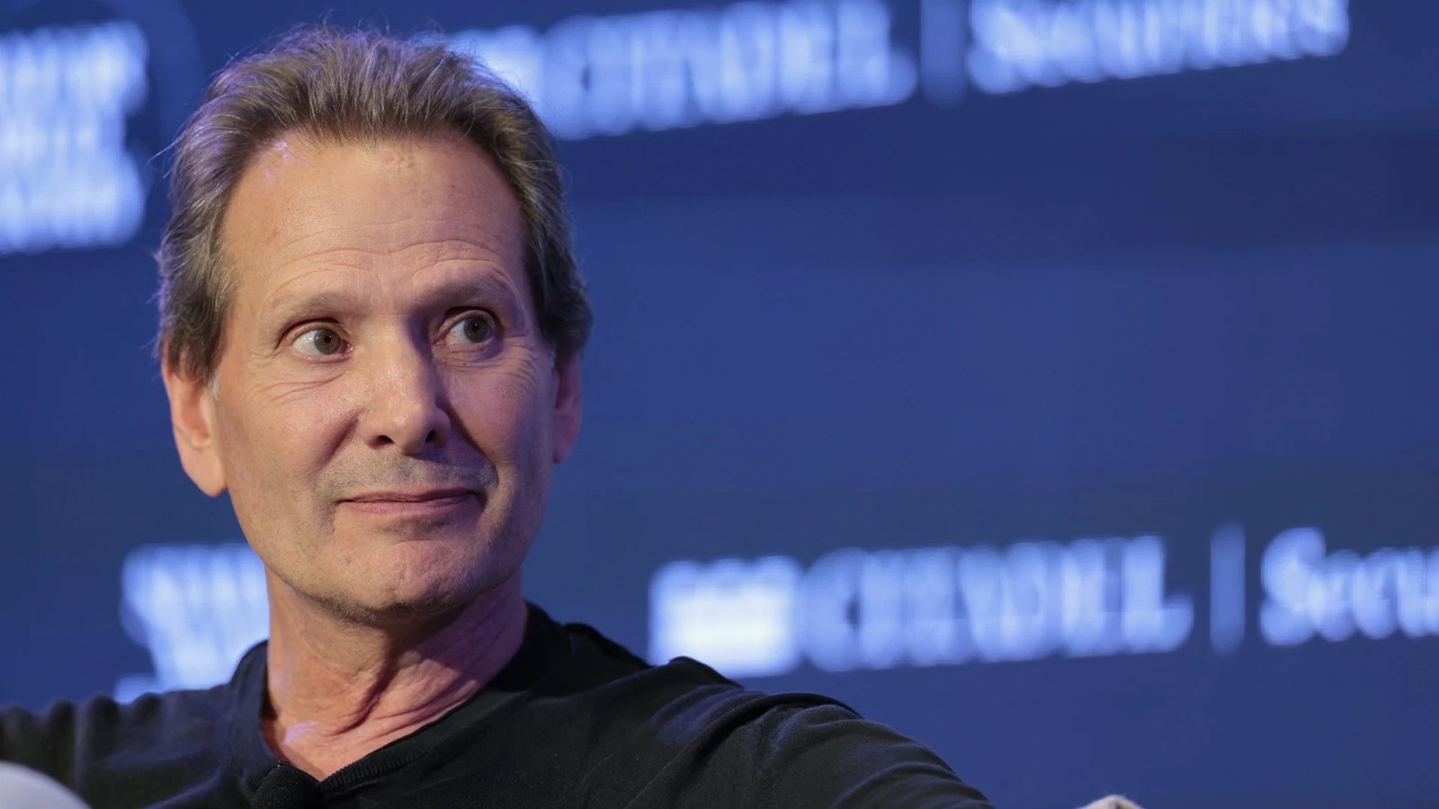 A person using a mobile phone in the UK, with a Verizon wireless extender in the background, highlighting the company's focus on customer service and innovative solutions