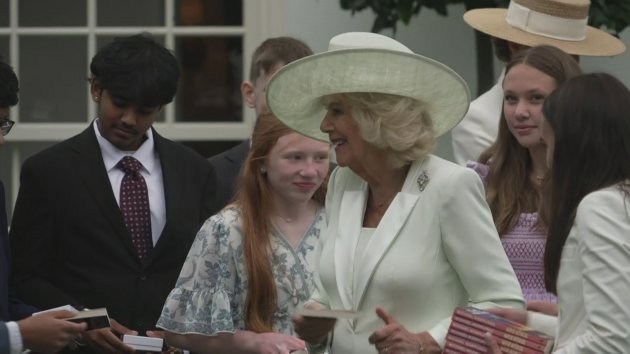 Queen Camilla and First Lady handing out gifts to happy youngsters, surrounded by colourful toys and excited faces, highlighting the joy of giving and sharing