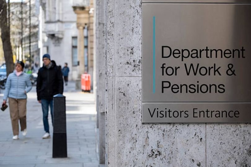 A person holding a tablet with the DWP website on the screen, with a concerned expression, highlighting the uncertainty surrounding the future of benefits and welfare in the UK, with a colour palette of blues and greys to convey a sense of seriousness and contemplation