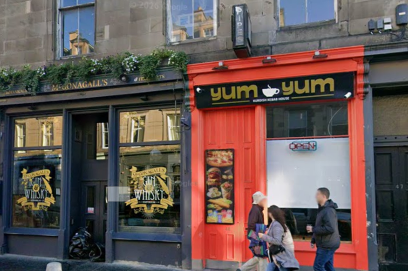 A photo of a car crashed into another vehicle, with a kebab shop in the background, highlighting the incident involving the Edinburgh kebab shop owner and the dangers of drunk driving