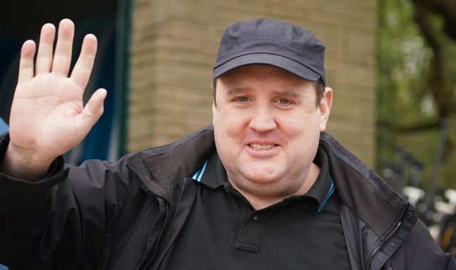 A photo of a suspicious bag being removed from a venue, with a caption that reads 'Security personnel removing a suspicious bag from a Peter Kay show in Birmingham, prompting evacuation and concern among the audience, with the primary keyword being 'suspicious bag'
