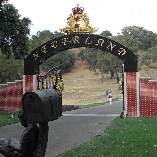 Aerial view of Michael Jackson's Neverland Ranch, featuring its lush gardens, private zoo, and amusement park, showcasing the vibrant colour and whimsical nature of the estate, with the primary keyword 'Neverland Ranch' highlighted as a symbol of the king of pop's creative and generous behaviour