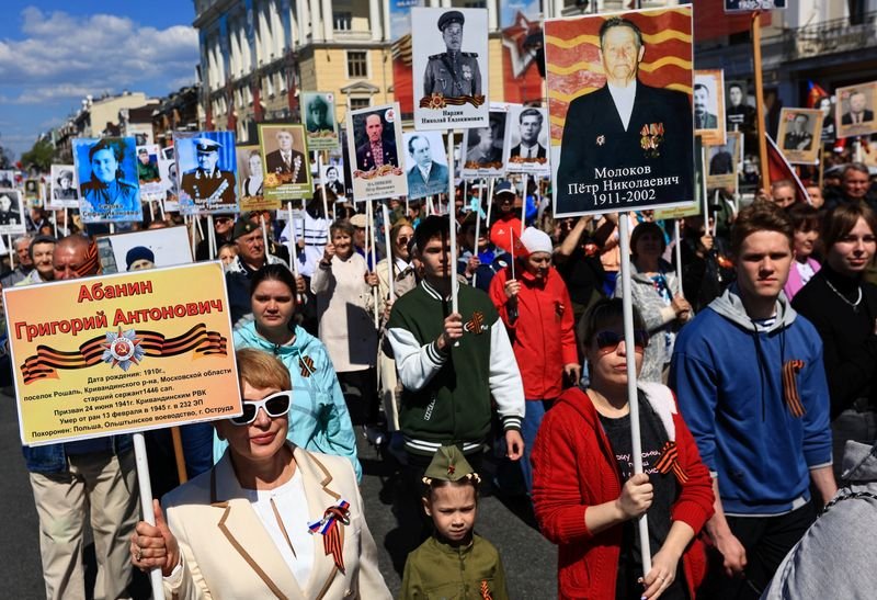 Russian troops marching during a scaled-back WW2 victory parade, with a focus on honouring the sacrifices of those who fought in the war, amidst the ongoing conflict in Ukraine