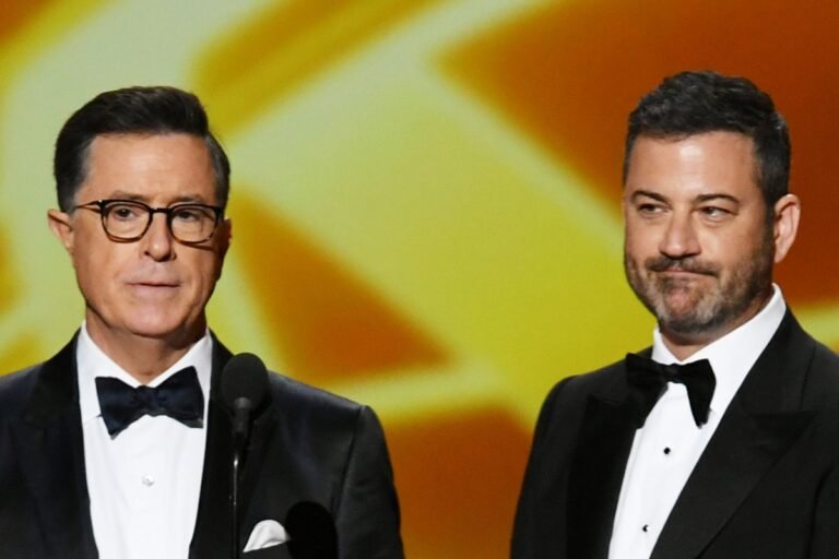 Jimmy Kimmel and Stephen Colbert pose together, symbolising their respect and admiration for each other as late-night hosts, with a colourful background representing the entertainment industry