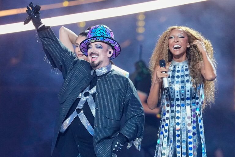 Boy George performing on stage with San Marino at the Eurovision Song Contest, a celebration of music, culture, and entertainment, with a captivating blend of excitement, drama, and spectacle, featuring a range of talented acts and memorable performances, including the iconic lead singer of Culture Club