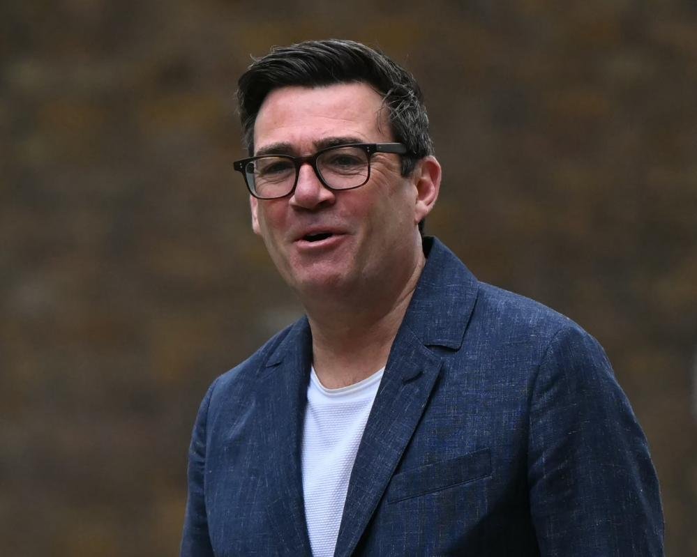 Andy Burnham speaking in parliament, with a determined look on his face, as he contemplates his next move in British politics, with the UK flag in the background, symbolising his commitment to the country and its people, and the complex political landscape that he navigates