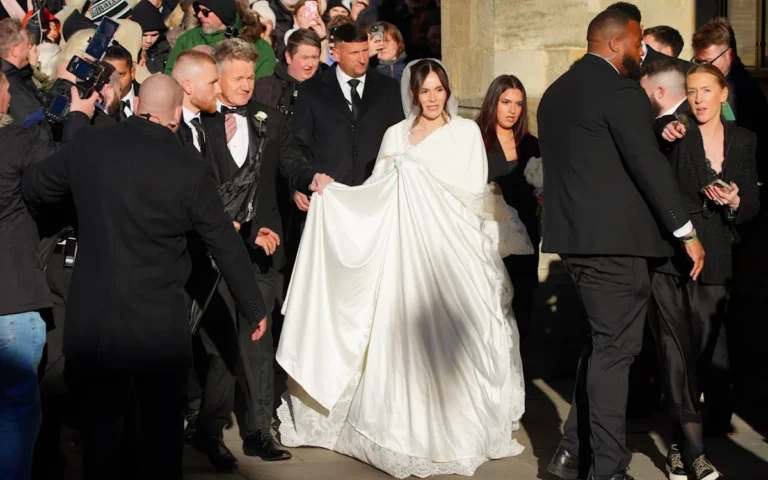 Gordon Ramsay standing in a kitchen, surrounded by culinary delights, with a thoughtful expression, analysing the Peaty family feud and his role in it, with a colour palette of warm and inviting tones