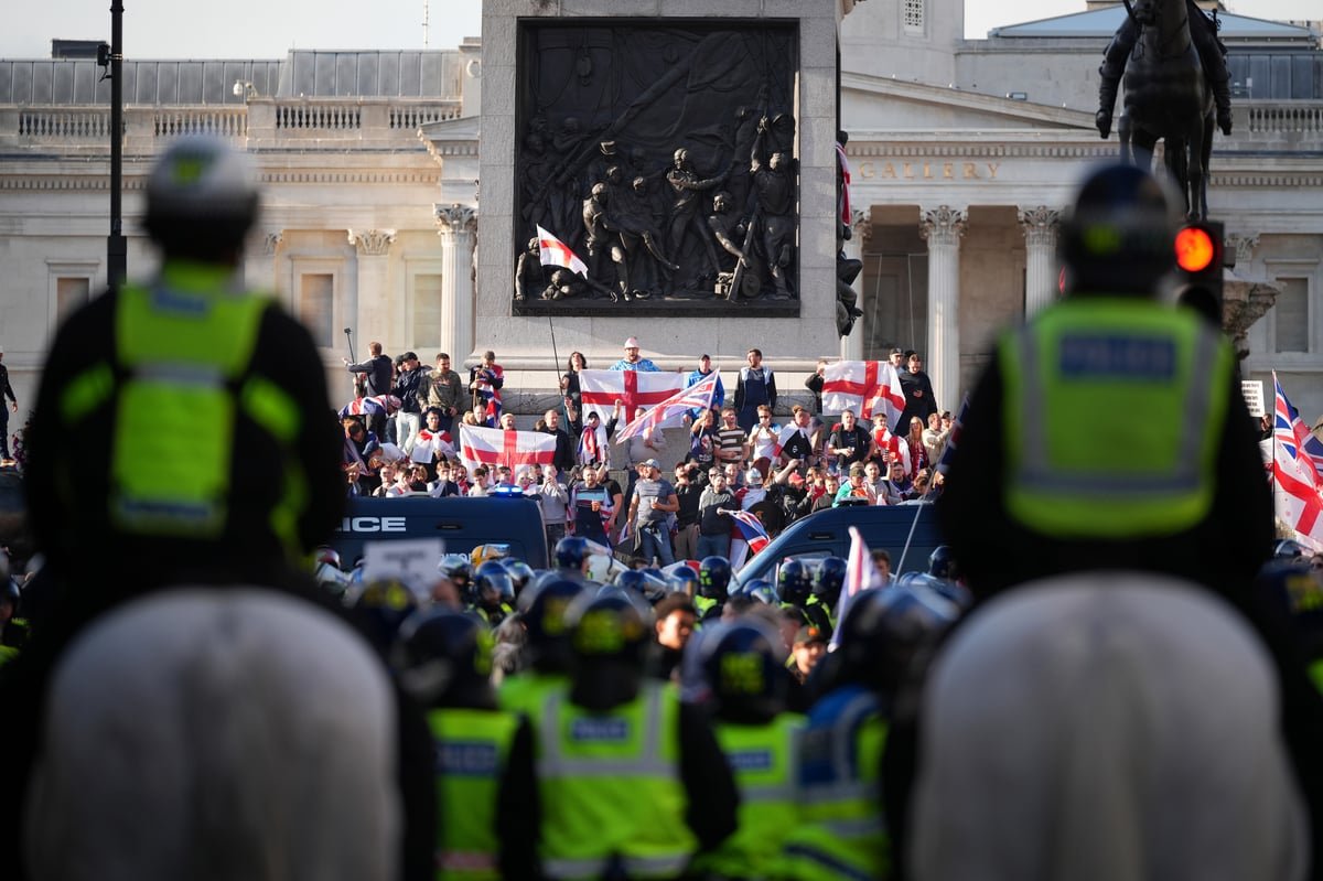 A large crowd of people gathered in London, with police officers visible in the background, as the city prepares for the FA Cup Final and a march led by Tommy Robinson, with concerns about potential football yob violence and unrest