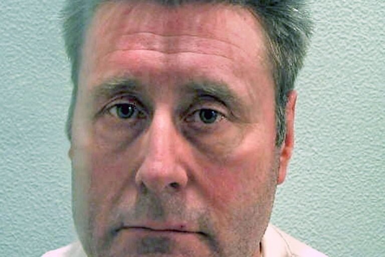 A black cab parked on a London street at night, with a blurred figure of a woman in the background, symbolising the fear and vulnerability of Worboys' victims, with a focus on the primary keyword 'black cab rapist'