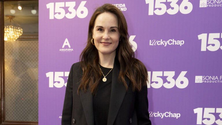 Michelle Dockery, a renowned actress, cradles her newborn baby in her arms, beaming with joy and happiness, as she embarks on her new role as a mother, surrounded by love and warmth, with a gentle smile on her face, and a sparkle in her eyes, as she navigates the challenges of motherhood with courage and resilience.