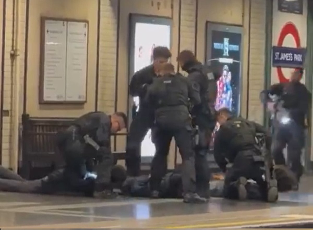 Armed Met Police officers at a London Tube station, detaining suspects in a dramatic arrest, with a city landscape in the background, showcasing the police's commitment to keeping London safe and secure, with a focus on the primary keyword, Met Police