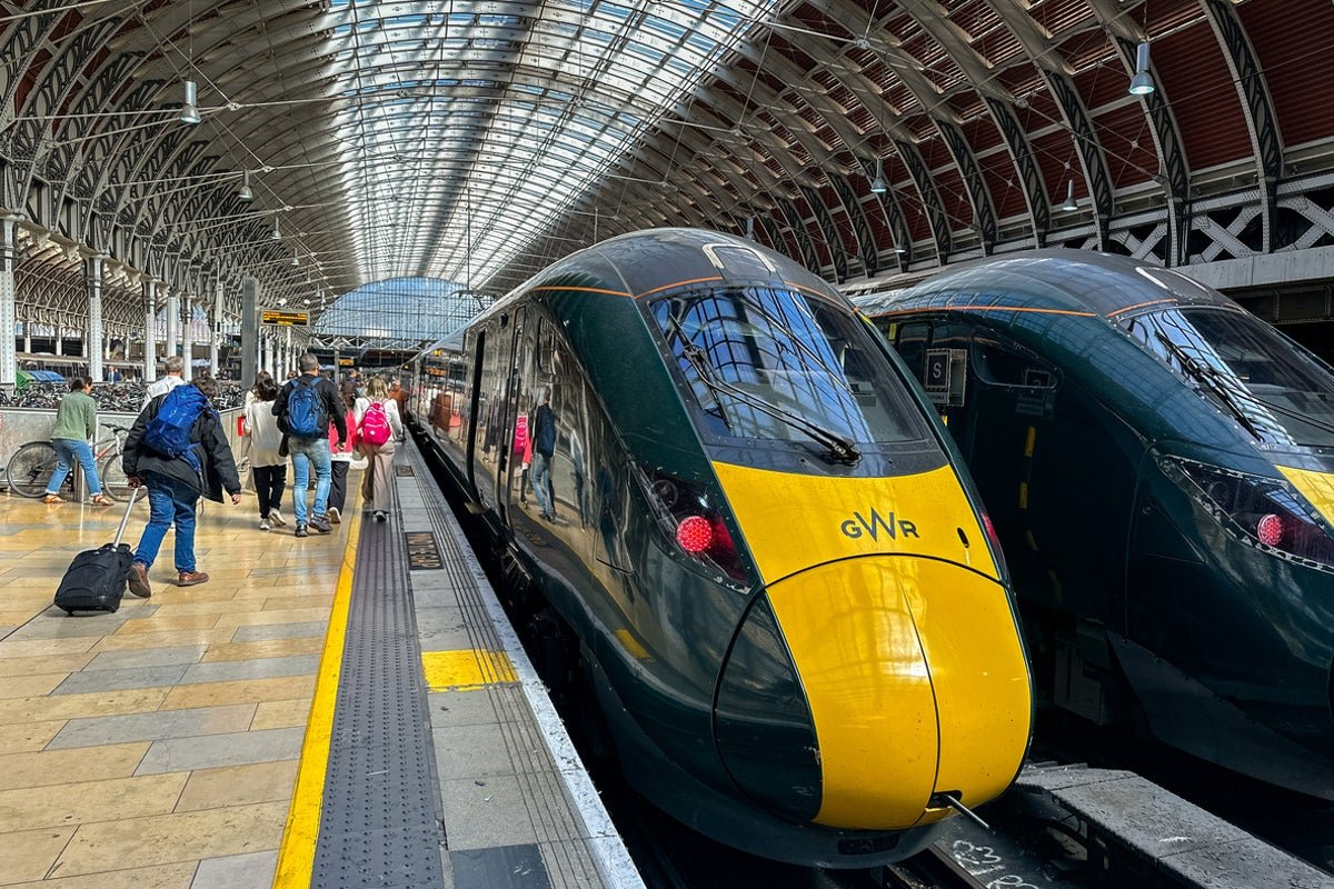 A crowded train station with passengers waiting for delayed trains, highlighting the impact of the nationwide rail issue on UK commuters and travellers, with a focus on train delays