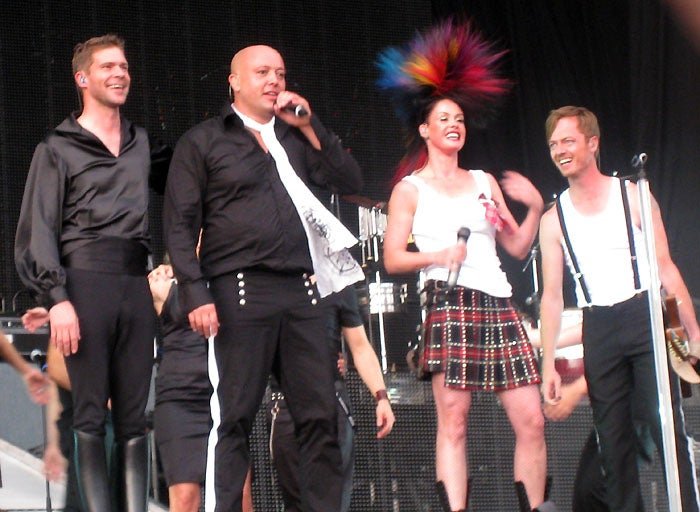Aqua band members posing together, with colourful backgrounds and quirky expressions, showcasing their unique behaviour and style, with the primary keyword 'Aqua' featured naturally in the image, highlighting their contribution to the music industry
