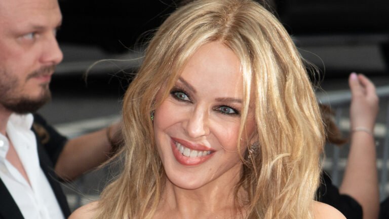 Kylie Minogue smiling and standing strong, a testament to her bravery and resilience in the face of cancer, with a colourful background representing hope and awareness