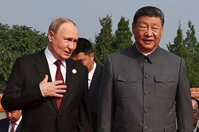 Vladimir Putin and Donald Trump shake hands, with the Russian and Chinese flags in the background, as the Russian economy struggles to stay afloat, with Putin's economic challenges and behaviour under close scrutiny