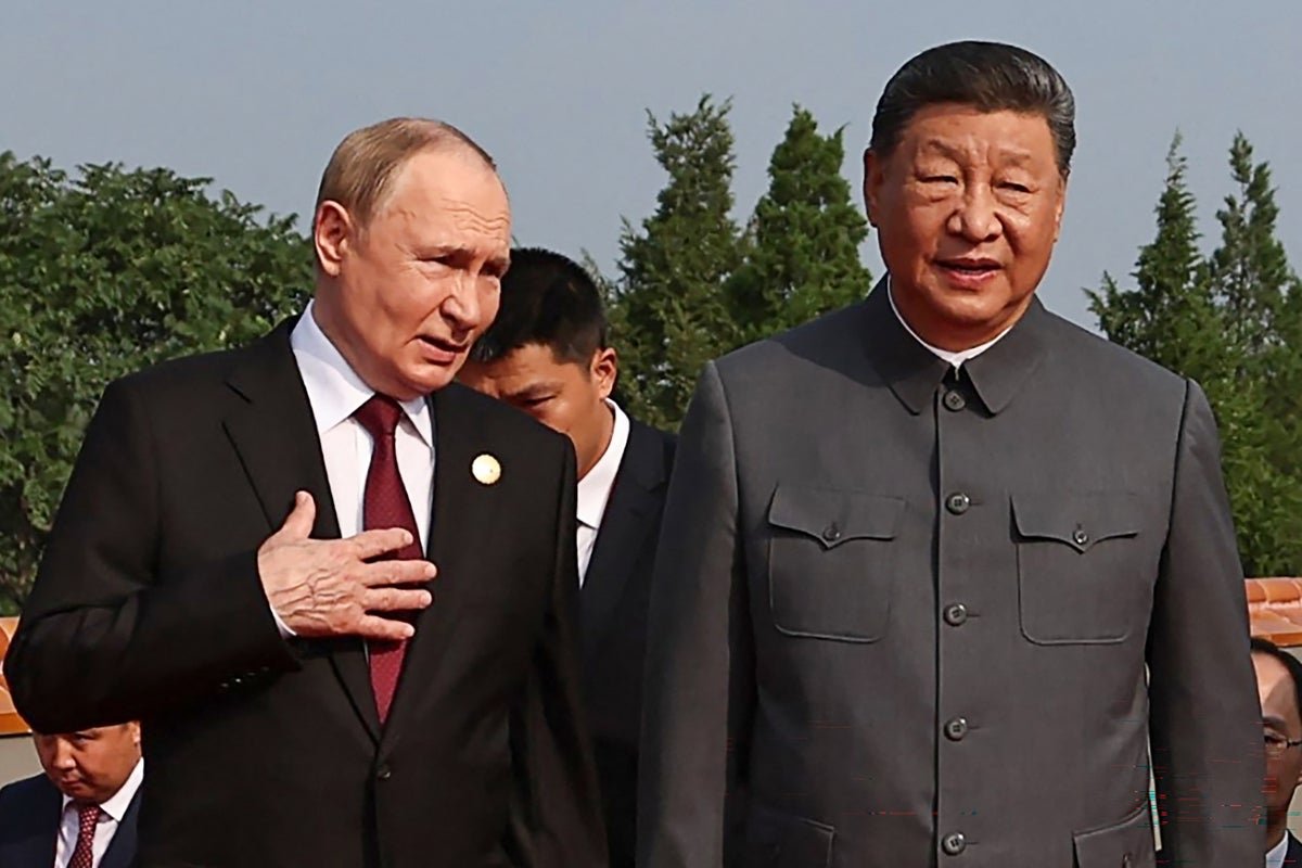 Vladimir Putin and Donald Trump shake hands, with the Russian and Chinese flags in the background, as the Russian economy struggles to stay afloat, with Putin's economic challenges and behaviour under close scrutiny